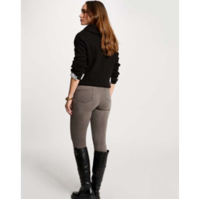 Mulher de casaco preto, calças cinza e botas pretas vista de costas