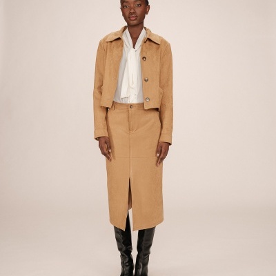 Conjunto de casaco curto e saia lápis castanhos com camisa branca e botas pretas