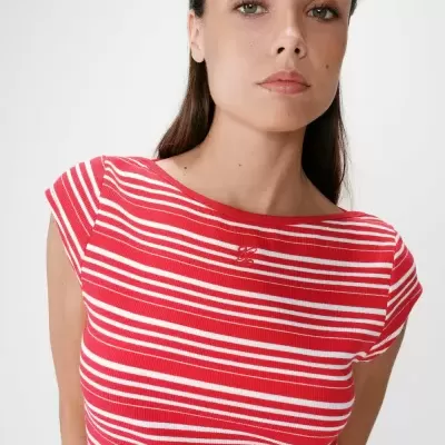 T-shirt riscada vermelha e branca com logótipo bordado em modelo feminino.