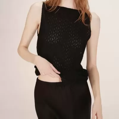 Top preto sem mangas com padrão geométrico transparente e saia preta lisa