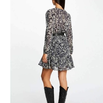 Mulher vista de costas usando vestido floral preto e branco com cinto preto e botas pretas