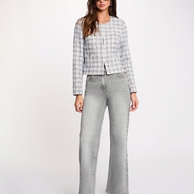 Mulher com blazer xadrez, jeans cinza largo e botins pretos