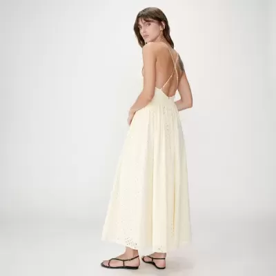 Vestido longo amarelo claro com padrão e alças cruzadas nas costas.