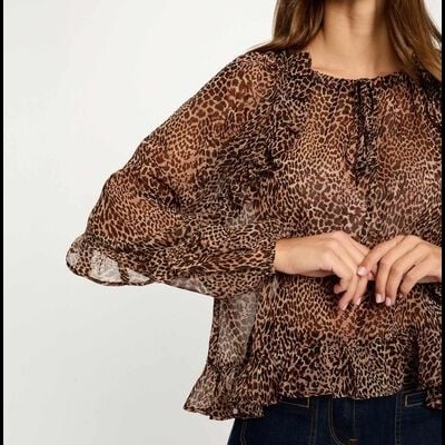 Blusa feminina transparente em padrão animal print castanho e preto com mangas bufantes.