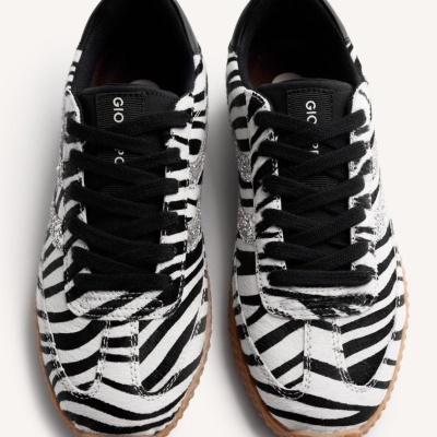 Ténis riscado preto e branco com sola castanha e detalhes prateados