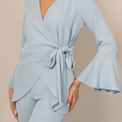 Blusa azul claro com mangas sino e amarração na cintura, combinada com calças iguais.