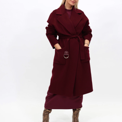 Mulher com casaco longo vinho com cinto e botas metálicas douradas