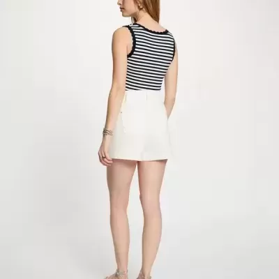 Mulher de costas com top às riscas preto e branco e calções brancos curtos