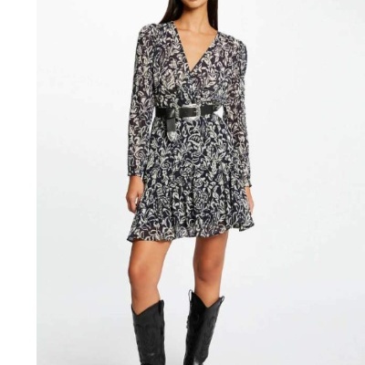 Mulher a usar vestido curto florido preto e branco com cinto preto e botas pretas