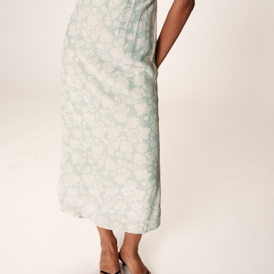 Vestido midi azul claro com padrão floral branco e sandálias pretas