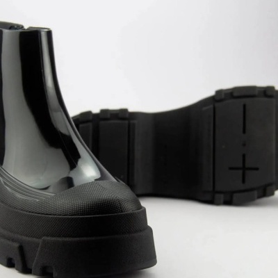 Botas pretas com sola grossa e textura brilhante