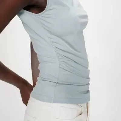 Top azul claro com franzido lateral e calças brancas com bolso