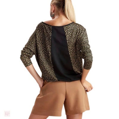 Mulher de costas com blusa animal print e calções castanhos