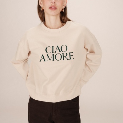 Mulher a usar sweatshirt bege com texto 