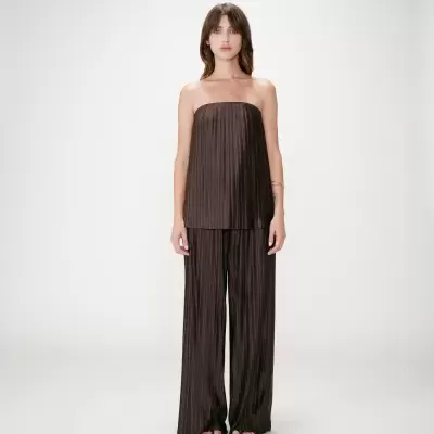 Mulher com conjunto castanho plissado em fundo branco