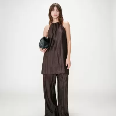 Conjunto de túnica e calças plissadas castanhas escuras com mala preta e sapatos brancos