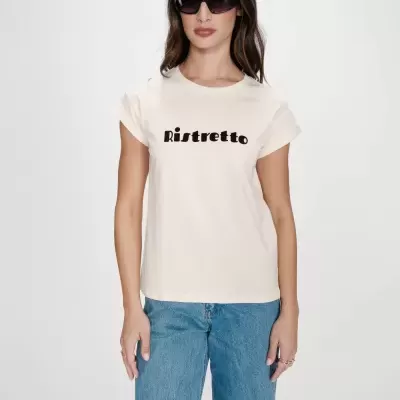 Mulher a usar t-shirt creme com texto preto Ristretto e calças de ganga azuis.