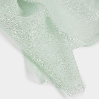 tecido verde claro com brilho prateado e franjas nas extremidades
