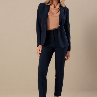 Mulher a vestir fato azul escuro com blusa bege e sapatos de salto alto bege