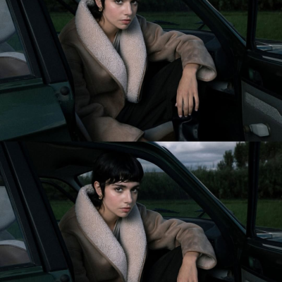 Mulher com casaco bege de pelo branco sentada em carro verde.