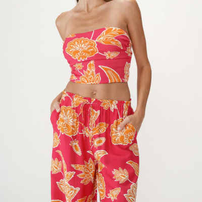 Conjunto feminino vermelho com padrão floral laranja e branco, top tomara que caia e calças largas com cintura elástica.