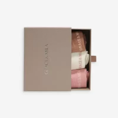 Caixa castanho claro com três pares de meias em castanho, branco e rosa