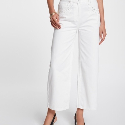 Calças brancas com botões pretos e sapatos pretos de salto