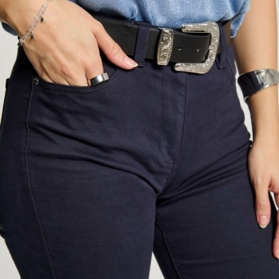 Calças azul escuro com cinto preto e fivela prateada, com t-shirt azul claro, acessórios prateados