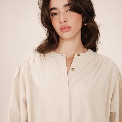 blusa bege clara com botões dourados no decote