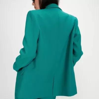 Blazer verde feminino com calças verdes e óculos de sol