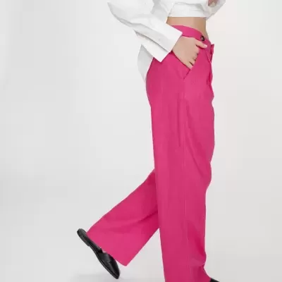 Calças rosa vibrantes de tecido largo com camisa branca e sapatos pretos