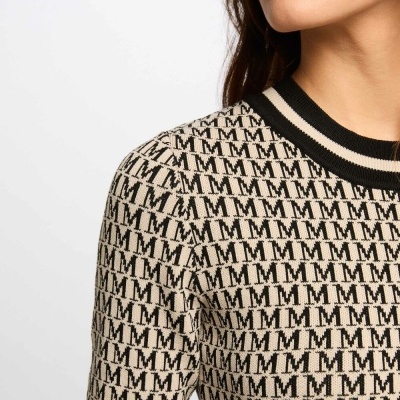 Top de malha bege com padrão 'M' repetido e gola preta