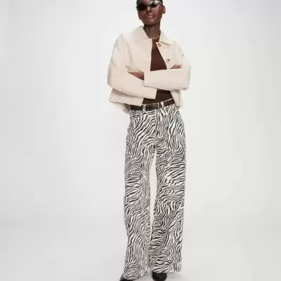 Mulher com calças de padrão zebra e casaco bege