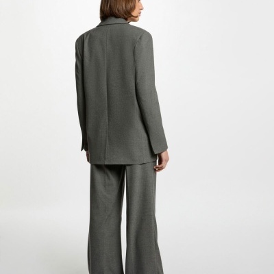 Conjunto de blazer e calças largas cinzentas em tecido texturado, modelo vista de costas.