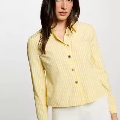 Camisa riscada amarela e branca com botões dourados, modelo feminino