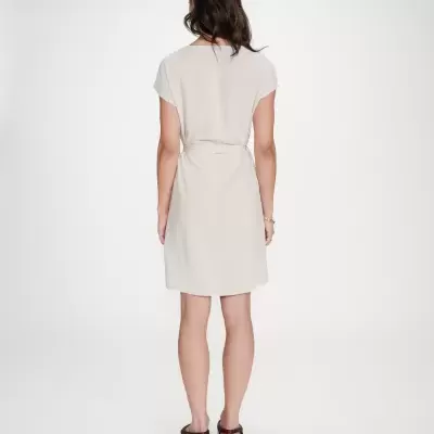 Vestido curto bege claro com cinto, visto por trás.