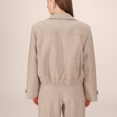 Ternos bege com padrão espinha de peixe vistos de trás.