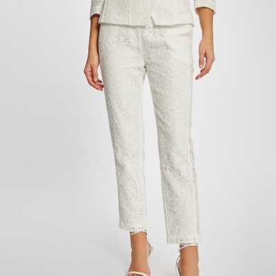 Calças femininas brancas de renda com corte reto combinadas com blazer branco