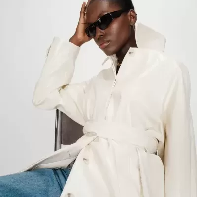 Casaco branco brilhante com cinto e óculos de sol pretos