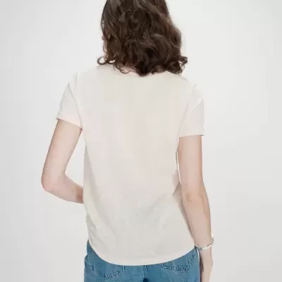 Pessoa de costas com t-shirt branca de manga curta e calças de ganga azuis