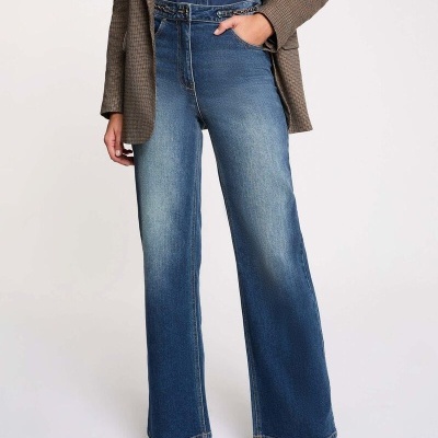 Calças de ganga azuis largas com cinto em corrente dourada e roupa combinada