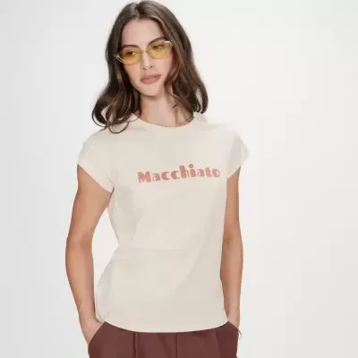 Mulher a usar t-shirt bege com texto Macchiato e óculos de sol amarelos