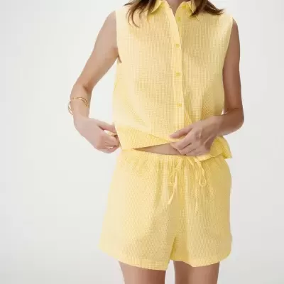 Conjunto amarelo xadrez feminino com camisa sem mangas e calções.