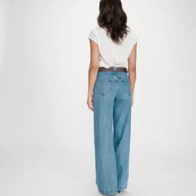 Calças de ganga largas azuis claras com quatro bolsos, usadas por mulher vista de costas, camiseta branca e cinto castanho