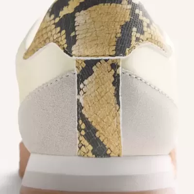 Parte traseira de ténis com padrão de pele de cobra e camurça cinza