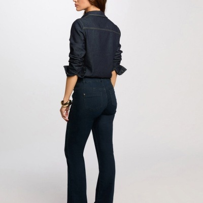 Mulher de costas com camisa e calças de ganga azul escuro