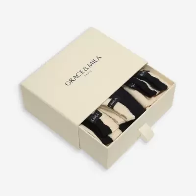 Caixa bege com texto GRACE & MILA PARIS contendo meias bege e pretas