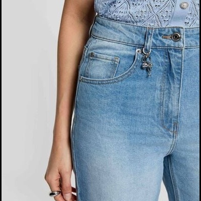 Jeans azul claro com camisa azul claro rendada e botão metálico