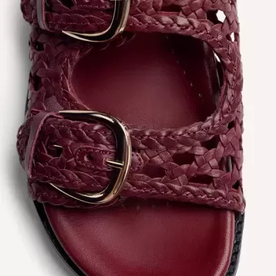 Sandália vermelha de couro com tiras entrelaçadas e fivelas douradas