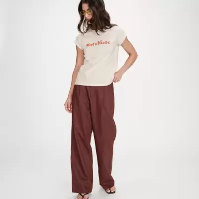 Mulher com t-shirt Macchiato e calças castanhas largas